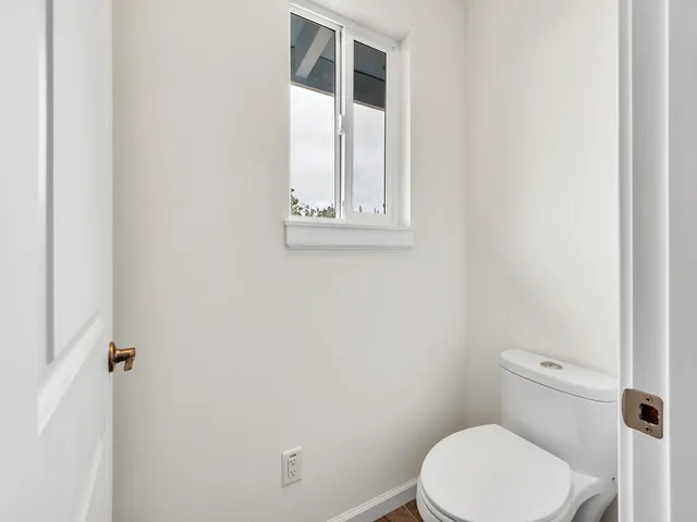 a white toilet sitting next to a window