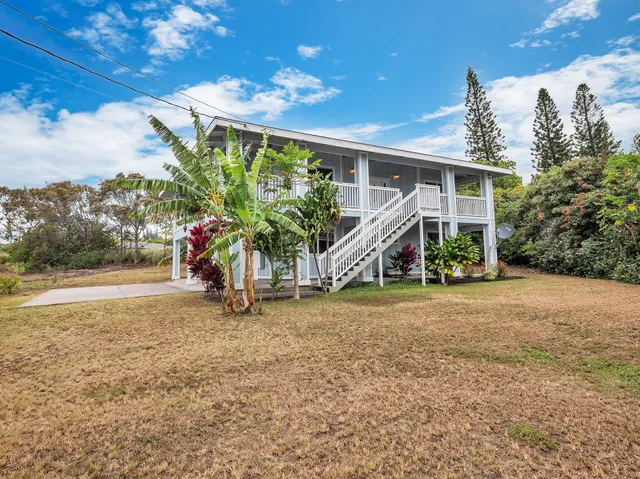 a view of an house with backyard and a patio