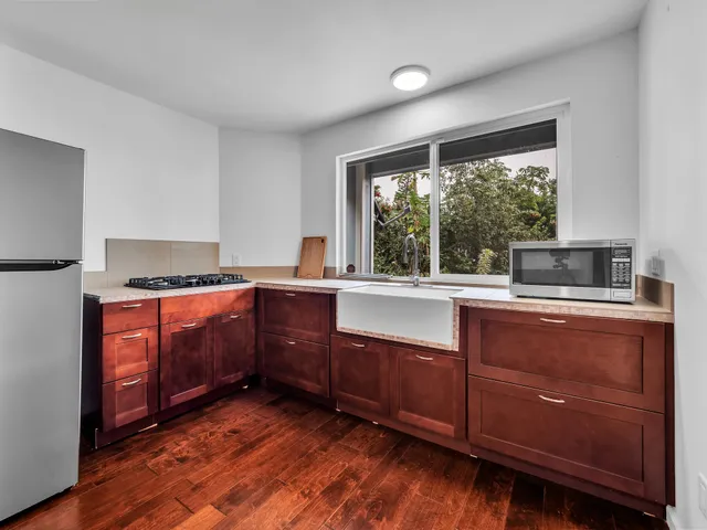 a kitchen with granite countertop a sink and wooden cabinets