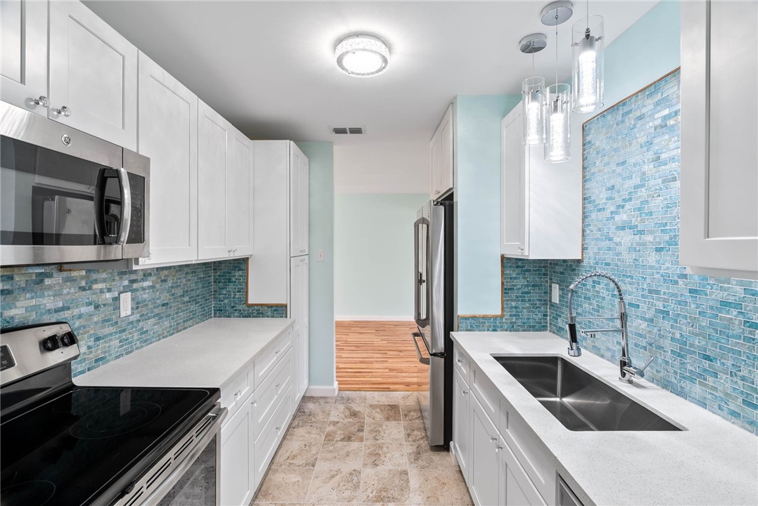 1703 Austin Street Portland, TX 78374 - Photo 10 of 13 a kitchen with a sink cabinets and stainless steel appliances