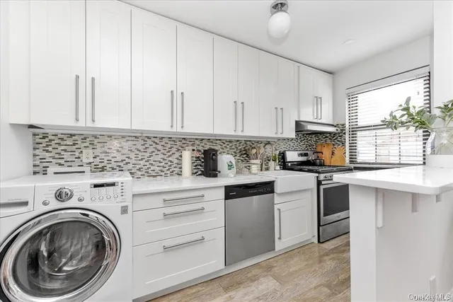 a kitchen with white cabinets and sink