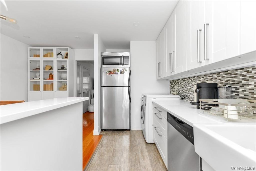 144-11 77th Road, Unit A Queens, NY 11367 - Photo 13 of 19 a kitchen with a refrigerator a stove a sink and a counter space