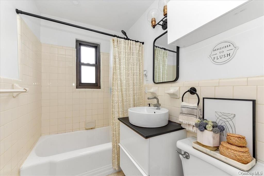 144-11 77th Road, Unit A Queens, NY 11367 - Photo 17 of 19 a bathroom with a sink and a mirror