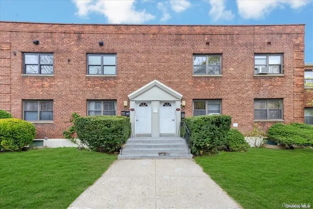 front view of a brick house with a yard