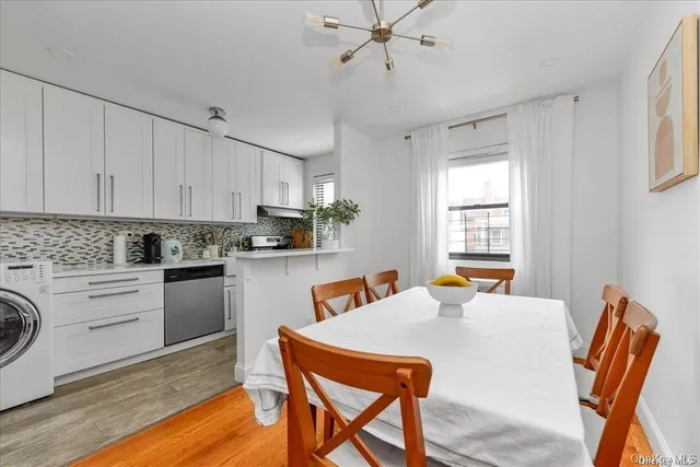 a kitchen with stainless steel appliances granite countertop a table chairs and a refrigerator