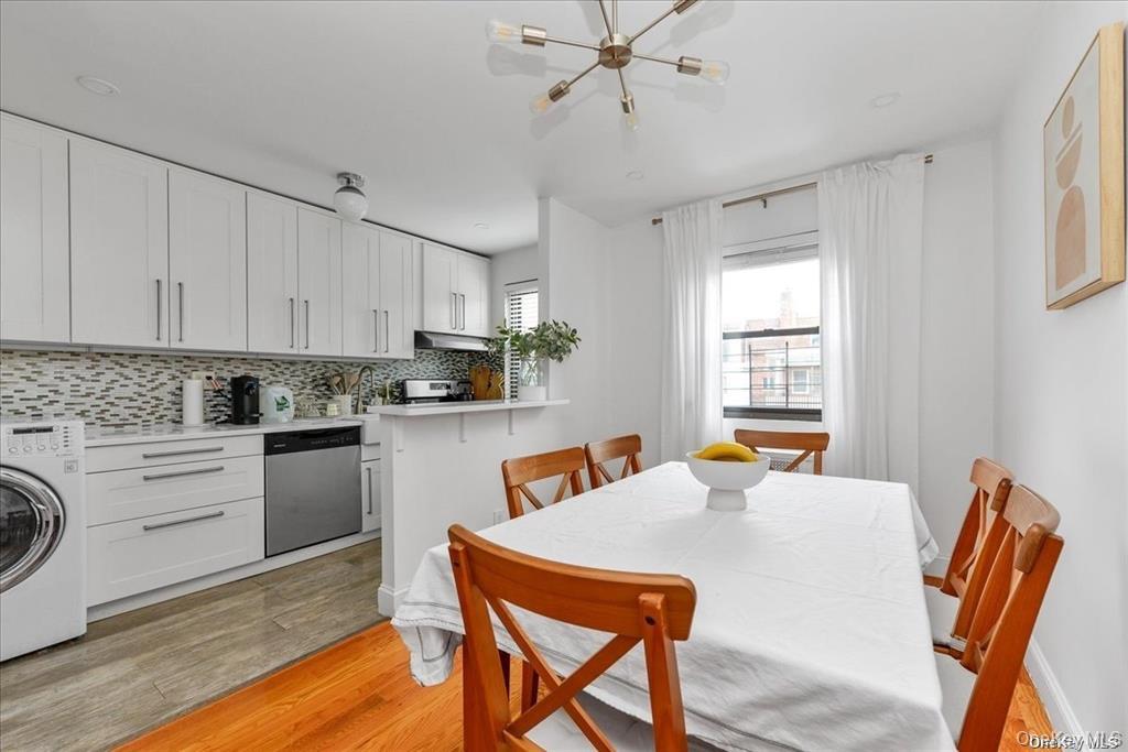 144-11 77th Road, Unit A Queens, NY 11367 - Photo 10 of 19 a kitchen with stainless steel appliances granite countertop a table chairs and a refrigerator