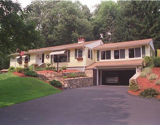 a front view of a house with a garden and yard