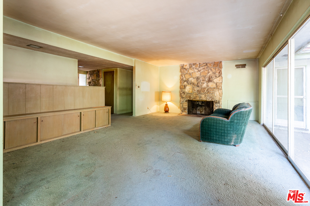 3469 Mandeville Canyon Road Los Angeles, CA 90049 - Photo 8 of 10 a living room with furniture and a fireplace