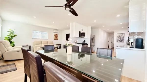 a view of kitchen with dining table wooden floor and stainless steel appliances