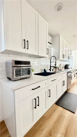 a kitchen with stainless steel appliances granite countertop a sink a stove and cabinets