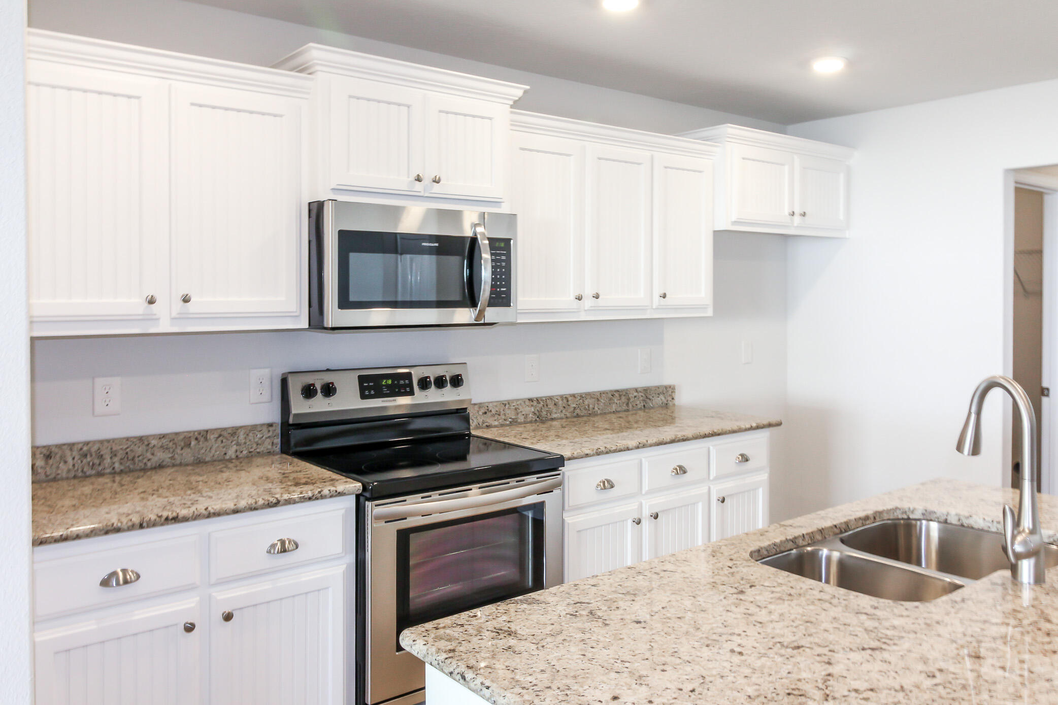 2613 Prominence Lane Crestview, FL 32536 - Photo 11 of 20 a kitchen with granite countertop a sink stove and microwave