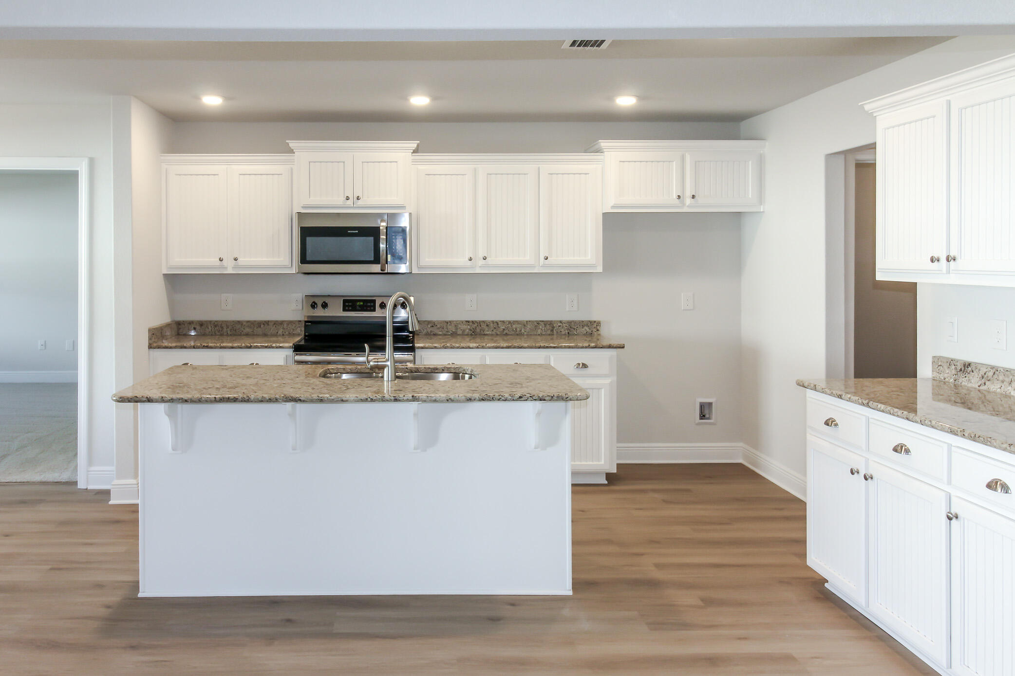 2613 Prominence Lane Crestview, FL 32536 - Photo 13 of 20 a kitchen with stainless steel appliances granite countertop a stove top oven a sink and white cabinets