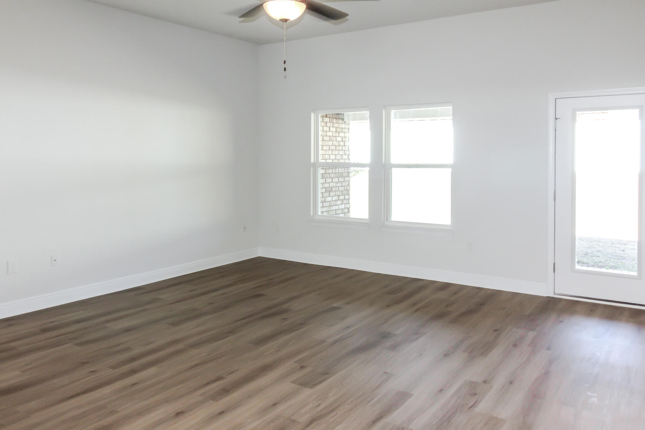 2613 Prominence Lane Crestview, FL 32536 - Photo 3 of 20 an empty room with wooden floor and windows