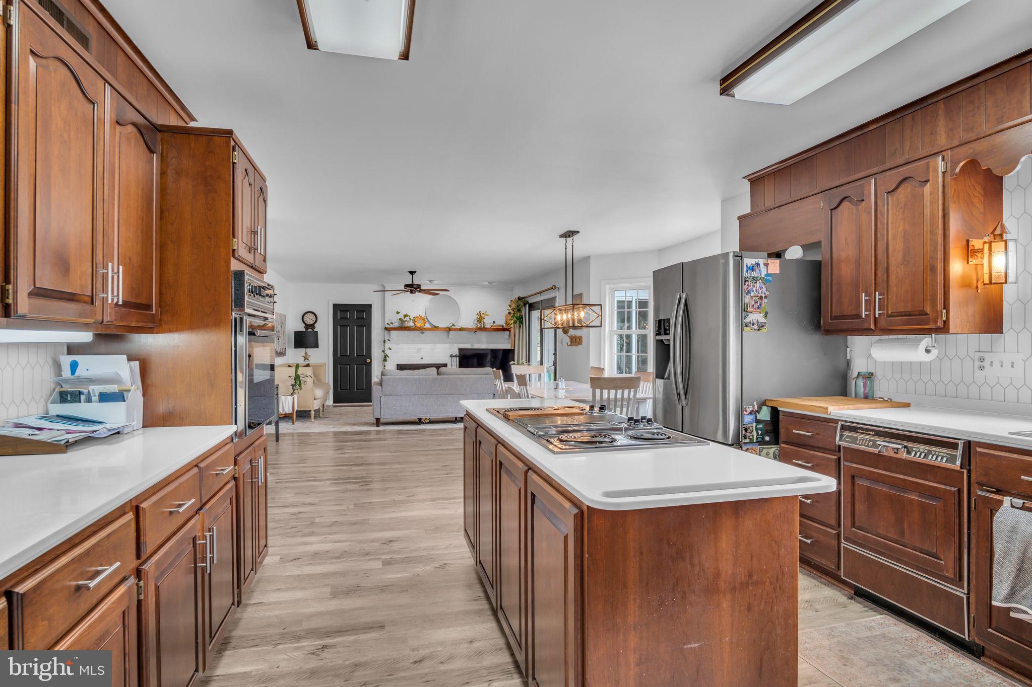 2242 Scotland Road Chambersburg, PA 17201 - Photo 12 of 63 a kitchen with stainless steel appliances granite countertop a stove top oven a refrigerator a sink and dishwasher wooden cabinets with wooden floor