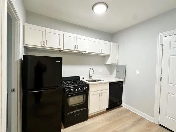 a kitchen with white cabinets and stainless steel appliances