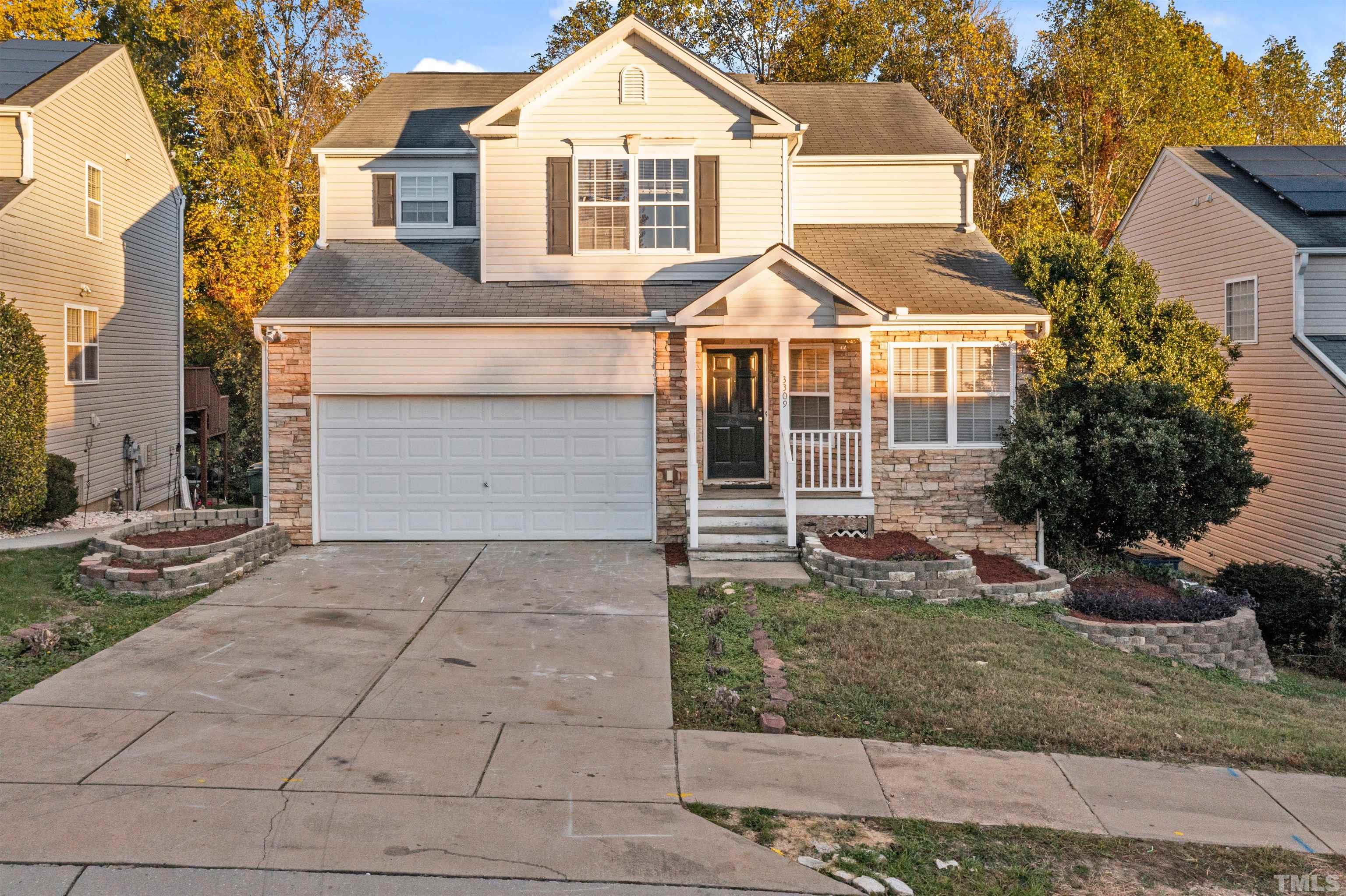 3309 Marshlane Way Raleigh, NC 27610 - Photo 22 of 24 a view of a white house with large windows and a yard with plants and large tree