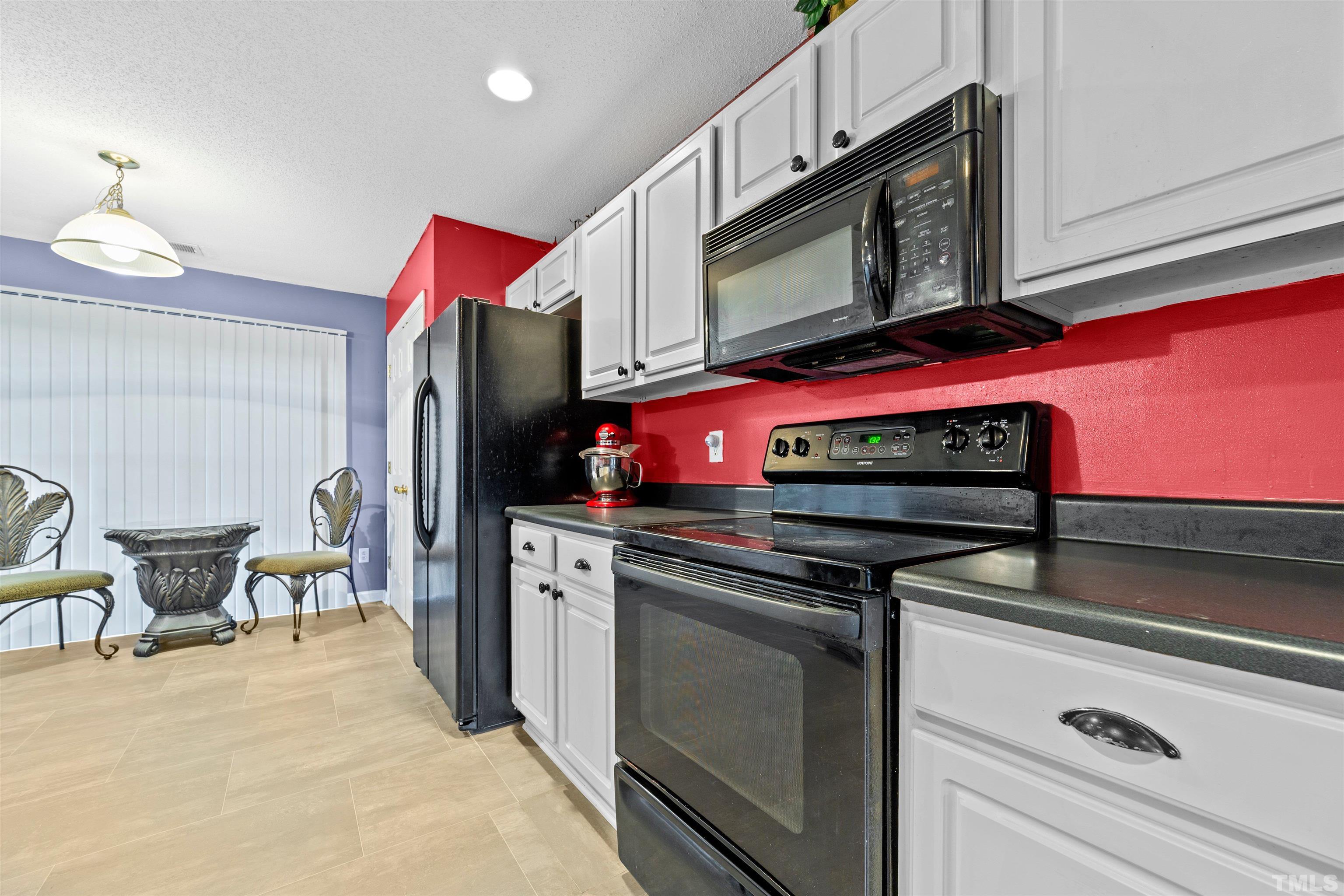 3309 Marshlane Way Raleigh, NC 27610 - Photo 8 of 24 a kitchen with stainless steel appliances a stove microwave and cabinets
