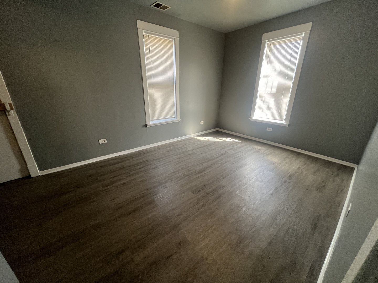 734 East 95th Street, Unit 1E Chicago, IL 60619 - Photo 5 of 7 an empty room with wooden floor and windows