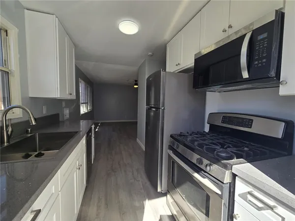 a kitchen with stainless steel appliances granite countertop a sink stove and refrigerator