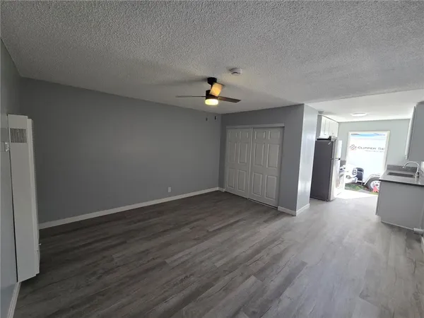 a view of a livingroom with wooden floor and a ceiling fan