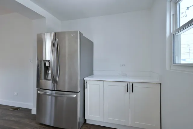a white refrigerator freezer and a wooden floor