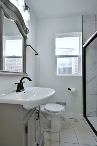 a bathroom with a sink a toilet and a mirror