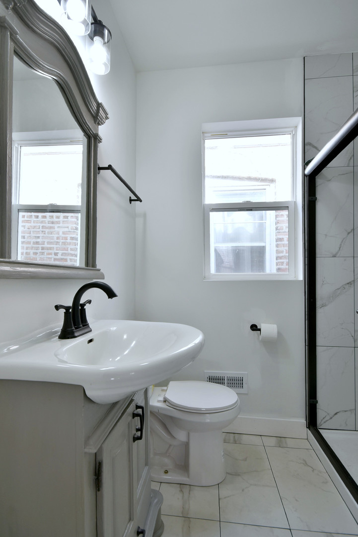 1405 South Central Avenue Cicero, IL 60804 - Photo 10 of 23 a bathroom with a sink a toilet and a mirror