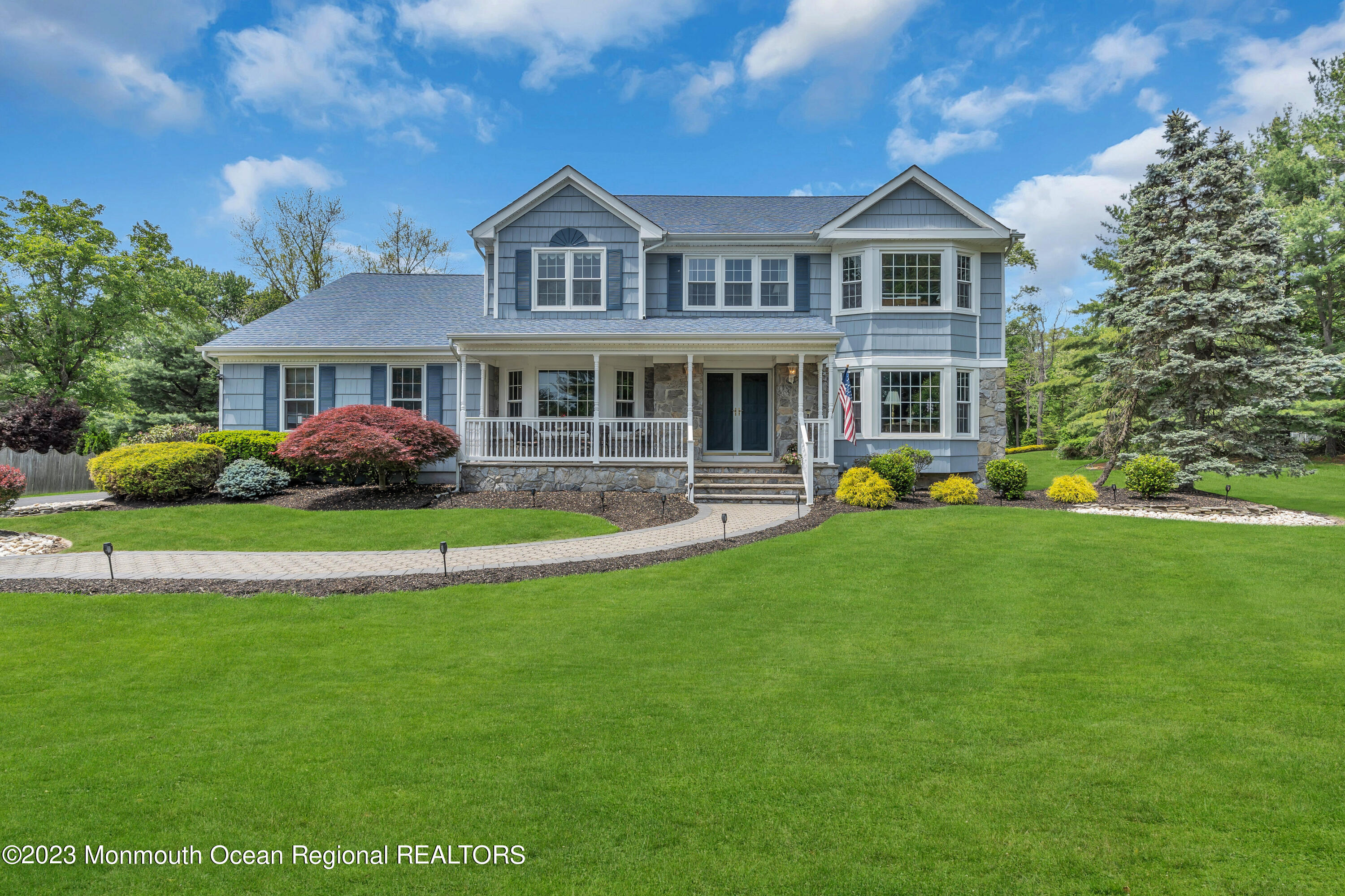 a front view of a house with garden and lots of trees