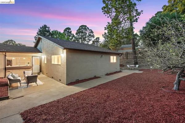 a backyard of a house with table and chairs