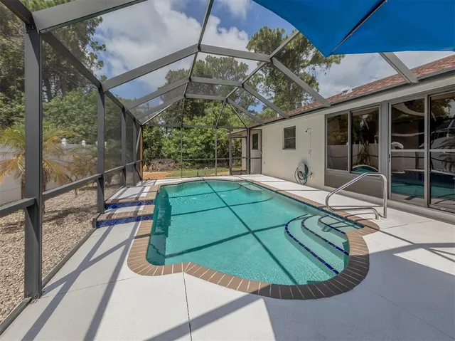 a kitchen with stainless steel appliances a sink a stove a refrigerator cabinets and dining table