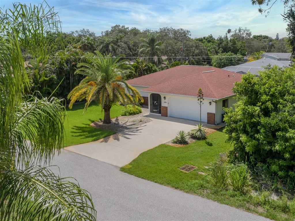 1211 Southland Road Venice, FL 34293 - Photo 2 of 80 an aerial view of a house with garden space and trees all around