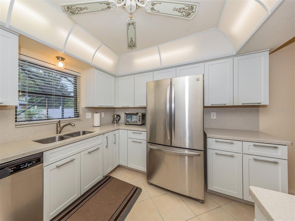 1211 Southland Road Venice, FL 34293 - Photo 21 of 80 a kitchen with white cabinets and white appliances