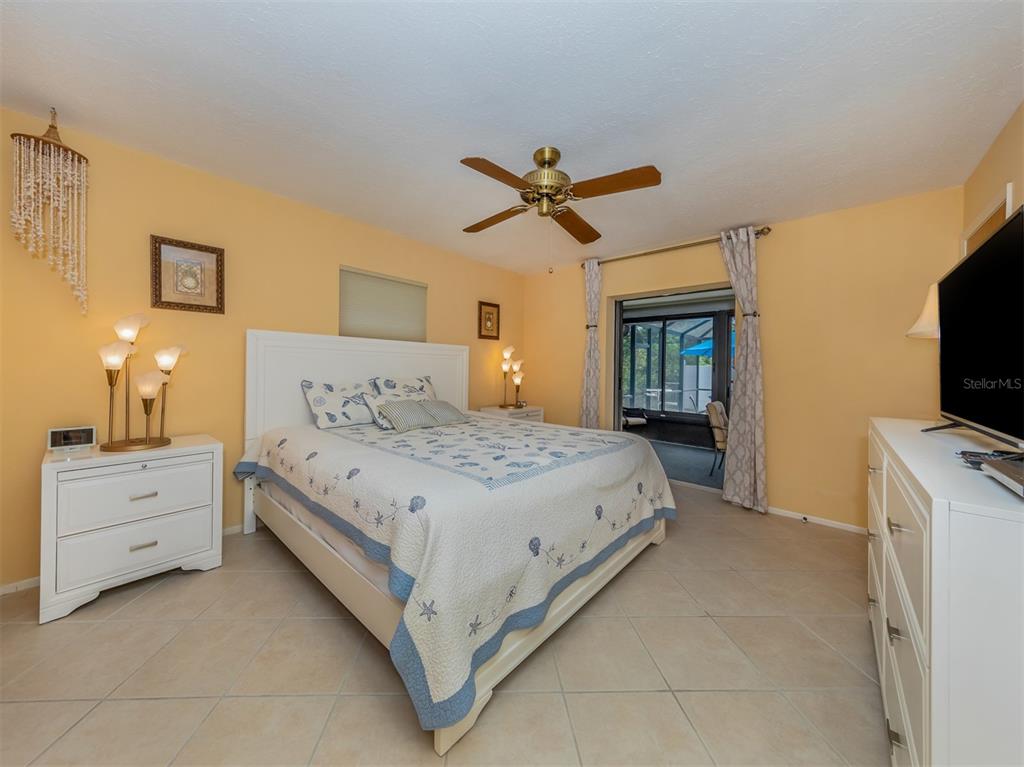 1211 Southland Road Venice, FL 34293 - Photo 32 of 80 a spacious bedroom with a bed and a flat screen tv