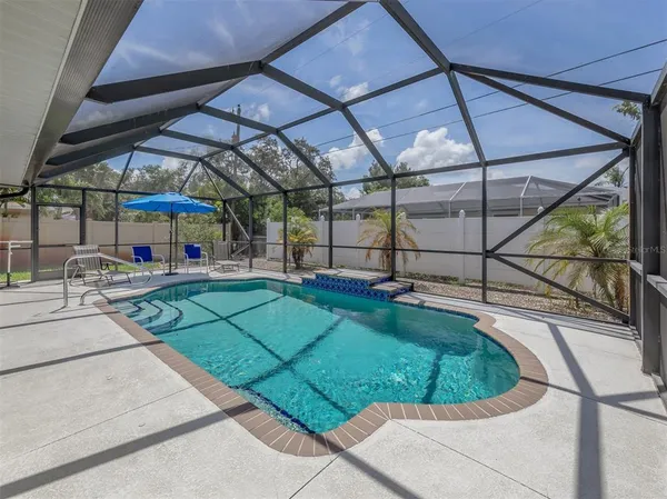 a view of a backyard with a tub and chairs under an umbrella