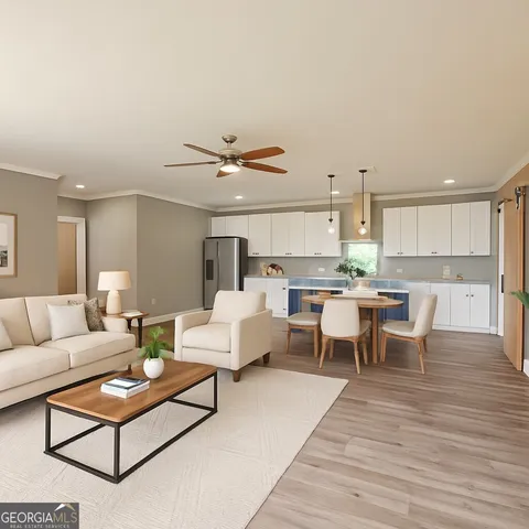 a living room with furniture kitchen view and a wooden floor