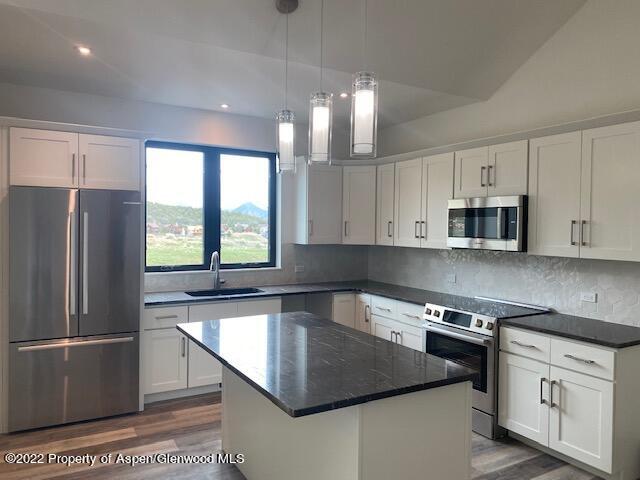 298 Blackhawk Drive New Castle, CO 81647 - Photo 4 of 15 a kitchen with stainless steel appliances granite countertop a refrigerator a sink a stove and white cabinets