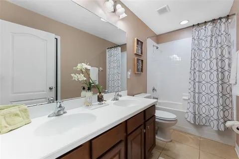 a bathroom with a double vanity sink toilet and a mirror