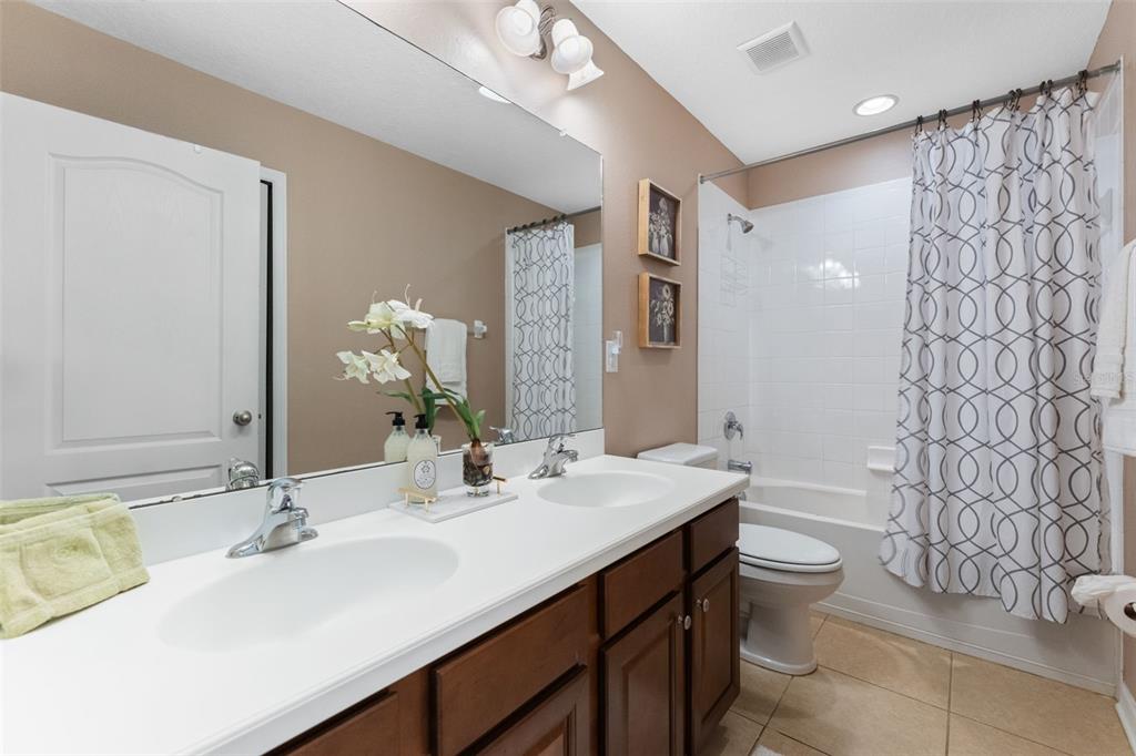 6058 Fishhawk Crossing Boulevard Lithia, FL 33547 - Photo 19 of 47 a bathroom with a double vanity sink toilet and a mirror