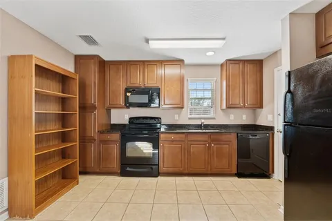 a kitchen with granite countertop a refrigerator and a sink
