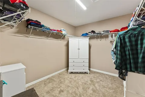 a view of walk in closet with clothes and shoes