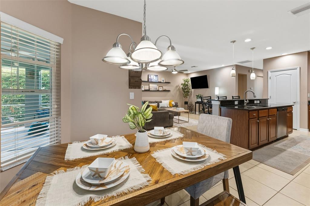 6058 Fishhawk Crossing Boulevard Lithia, FL 33547 - Photo 7 of 47 a table and chairs in a dining room with kitchen view