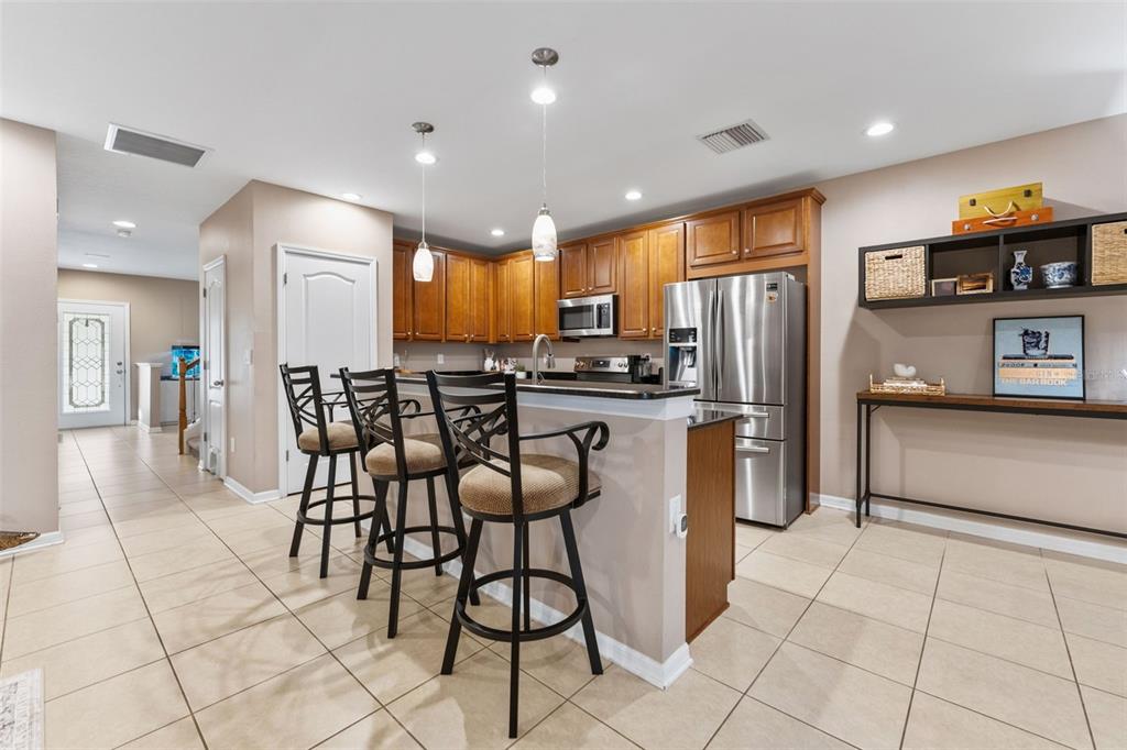 6058 Fishhawk Crossing Boulevard Lithia, FL 33547 - Photo 8 of 47 a kitchen with stainless steel appliances a refrigerator a stove a sink a dining table and chairs