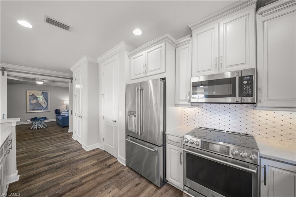 9685 Montelanico Loop, Unit 101 Naples, FL 34119 - Photo 11 of 49 a kitchen with a stove and a refrigerator
