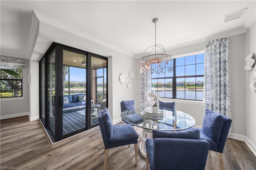 9685 Montelanico Loop, Unit 101 Naples, FL 34119 - Photo 12 of 49 a dining room with furniture a chandelier and wooden floor
