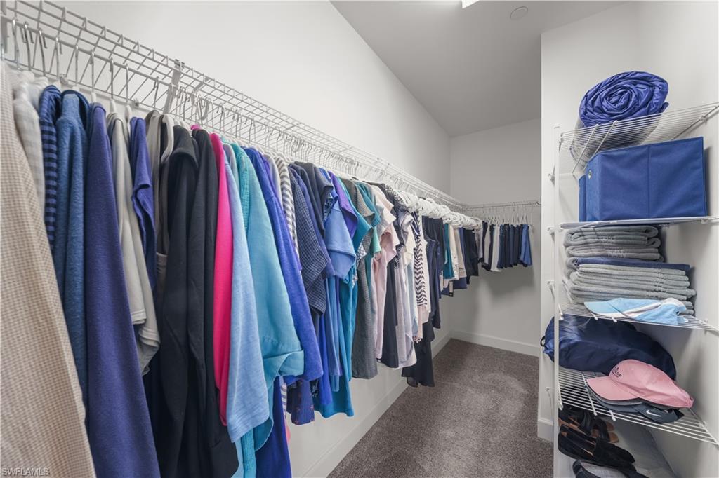 9685 Montelanico Loop, Unit 101 Naples, FL 34119 - Photo 22 of 49 a view of walk in closet with clothes