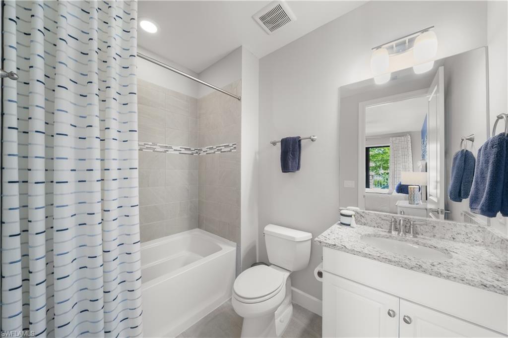9685 Montelanico Loop, Unit 101 Naples, FL 34119 - Photo 24 of 49 a bathroom with a granite countertop sink toilet mirror and shower
