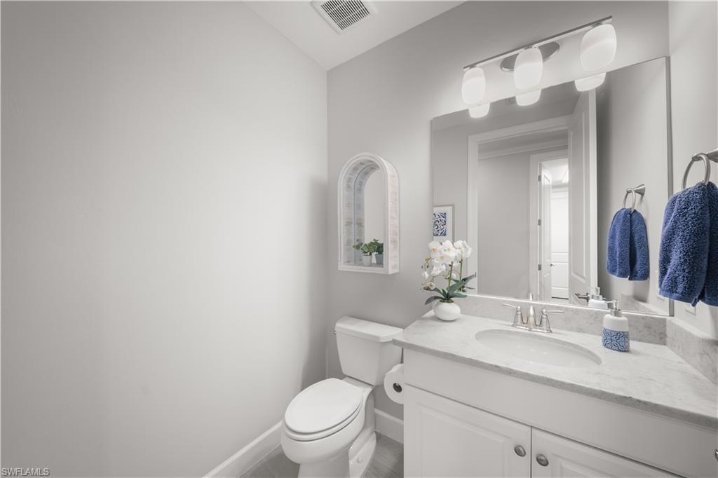 9685 Montelanico Loop, Unit 101 Naples, FL 34119 - Photo 26 of 49 a bathroom with a granite countertop sink mirror vanity and toilet
