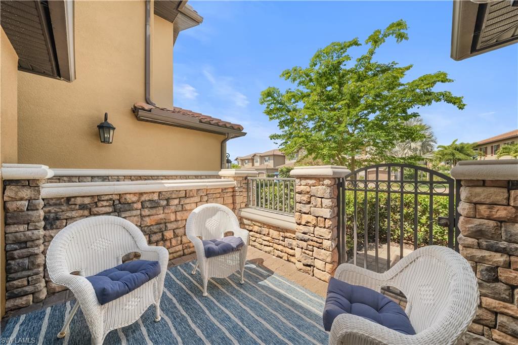 9685 Montelanico Loop, Unit 101 Naples, FL 34119 - Photo 28 of 49 a living room with furniture a rug and a floor to ceiling window