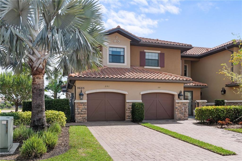 9685 Montelanico Loop, Unit 101 Naples, FL 34119 - Photo 29 of 49 a front view of a house with a garden and plants