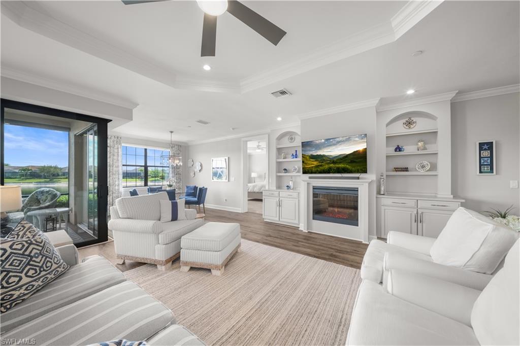9685 Montelanico Loop, Unit 101 Naples, FL 34119 - Photo 3 of 49 a living room with furniture fireplace and flat screen tv